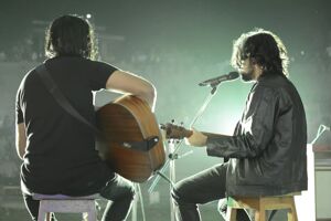 Two musicians playing guitar and singing together